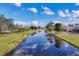 Picturesque view of a tranquil canal surrounded by lush greenery and residential properties at 604 Boundary Blvd, Rotonda West, FL 33947