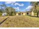 Backyard view of the home, screened patio, and storage shed at 6125 Higgins Ln, Englewood, FL 34224