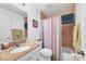 Bathroom featuring a granite countertop, a shower/tub combination, and a decorative shower curtain at 6125 Higgins Ln, Englewood, FL 34224