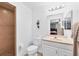 Bathroom with a tiled walk-in shower, white vanity, and decorative accents at 6125 Higgins Ln, Englewood, FL 34224