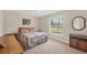 Bedroom with a quilt-covered bed, wood furniture, and natural light from a large window at 6125 Higgins Ln, Englewood, FL 34224