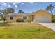 Charming yellow single-story home with attached two-car garage and well-maintained lawn at 6125 Higgins Ln, Englewood, FL 34224