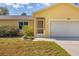 Up close view of a yellow home with mature landscaping at 6125 Higgins Ln, Englewood, FL 34224