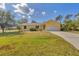A charming yellow home with a lush green lawn at 6125 Higgins Ln, Englewood, FL 34224