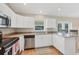 Kitchen featuring stainless steel appliances, white cabinets and granite countertops at 6125 Higgins Ln, Englewood, FL 34224