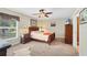 Cozy main bedroom with wood furniture, ceiling fan, and a window with natural light at 6125 Higgins Ln, Englewood, FL 34224