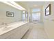 Bathroom with double vanity, soaking tub, and window at 6730 Greenview Ln, Englewood, FL 34224