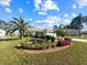 Landscaped front yard with palm trees and circular garden at 6730 Greenview Ln, Englewood, FL 34224