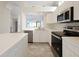 White kitchen with stainless steel appliances and breakfast bar at 6730 Greenview Ln, Englewood, FL 34224