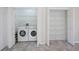 Bright laundry room with washer, dryer, and ample shelving at 6730 Greenview Ln, Englewood, FL 34224