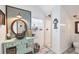 Bathroom with a teal vanity, round mirror, and a walk-in shower at 8888 Bay St, Placida, FL 33946