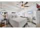 Guest bedroom with a white bed frame, ceiling fan, and wicker chair at 8888 Bay St, Placida, FL 33946
