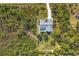 An aerial view of a beautifully landscaped property features a pool, shed, large yard, and mature trees at 9350 Loyola Ave, Englewood, FL 34224