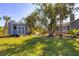 The backyard features a shed, landscaping, and a pathway that leads to the screened pool area at 9350 Loyola Ave, Englewood, FL 34224