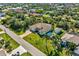 Aerial view of a suburban home with a screened-in pool, lush landscaping, and surrounding neighborhood at 9533 Arnaz Cir, Port Charlotte, FL 33981
