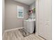 The laundry room has a washer and dryer, a utility closet, wood-look flooring, and a window at 9533 Arnaz Cir, Port Charlotte, FL 33981