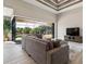 Living room showcasing a large sectional, ceiling fan, tray ceiling, and sliding glass doors to the pool at 9533 Arnaz Cir, Port Charlotte, FL 33981