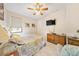 Inviting bedroom with a ceiling fan, a patterned bedspread, and an entertainment setup for relaxation and comfort at 9548 Applin Cir, Port Charlotte, FL 33981