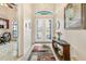 Bright foyer with decorative glass double doors, tiled floors, and charming console table at 9548 Applin Cir, Port Charlotte, FL 33981