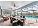 Relax on the covered lanai, complete with a dining set and a view of the inviting screened-in pool at 9548 Applin Cir, Port Charlotte, FL 33981