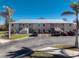 Ground-level condo building with parking and tropical landscaping at 9900 Fiddlers Green Cir # 137, Rotonda West, FL 33947