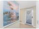 Hallway with beach-themed art and door to patio at 9900 Fiddlers Green Cir # 137, Rotonda West, FL 33947