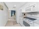 White kitchen with appliances and view to hallway at 9900 Fiddlers Green Cir # 137, Rotonda West, FL 33947