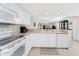 White kitchen with breakfast bar and view to living room at 9900 Fiddlers Green Cir # 137, Rotonda West, FL 33947