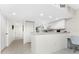 White kitchen with breakfast bar and view of hallway at 9900 Fiddlers Green Cir # 137, Rotonda West, FL 33947