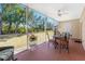 Relaxing screened lanai with table and chairs, overlooking a lush green backyard at 9900 Fiddlers Green Cir # 137, Rotonda West, FL 33947