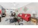 Bright living room with red sofa and view into dining area at 9900 Fiddlers Green Cir # 137, Rotonda West, FL 33947