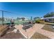Community patio with grill, picnic table, and tennis court views at 9900 Fiddlers Green Cir # 137, Rotonda West, FL 33947
