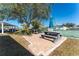 Community patio with grill, picnic table, and tennis court views at 9900 Fiddlers Green Cir # 137, Rotonda West, FL 33947