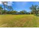 Large grassy backyard showcasing the home's screened enclosure at 1080 Bayshore Dr, Englewood, FL 34223