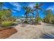 Single-story home with palm trees and a gravel driveway at 1080 Bayshore Dr, Englewood, FL 34223