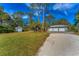 Home exterior featuring a three-car garage and a storage shed at 1080 Bayshore Dr, Englewood, FL 34223