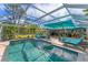 Inviting pool area with covered patio, lounge chairs, and lush landscaping at 1080 Bayshore Dr, Englewood, FL 34223