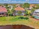 Beautiful aerial view of a home with a screened in pool and lush landscaping in a gated community at 13347 Golf Pointe Dr, Port Charlotte, FL 33953