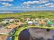 Scenic aerial view of upscale homes nestled along a serene pond within a well-maintained community at 13347 Golf Pointe Dr, Port Charlotte, FL 33953