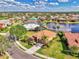 Aerial shot showcasing a landscaped home with tile roof and lake view in a beautiful community at 13347 Golf Pointe Dr, Port Charlotte, FL 33953