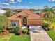 An elevated perspective of this beautiful home with terracotta roof, lake view, and manicured landscaping at 13347 Golf Pointe Dr, Port Charlotte, FL 33953