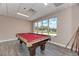 Cozy billiard room featuring a red felt pool table, large window, and cue rack at 13347 Golf Pointe Dr, Port Charlotte, FL 33953