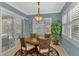 Elegant dining room featuring a round table, stylish chairs, a decorative chandelier, and views of the pool at 13347 Golf Pointe Dr, Port Charlotte, FL 33953