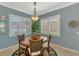 Dining area featuring a round table with seating for four, a chandelier, and serene light-filled views at 13347 Golf Pointe Dr, Port Charlotte, FL 33953