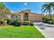 Charming home with a terracotta roof, lush landscaping, and well-manicured lawn on a sunny day at 13347 Golf Pointe Dr, Port Charlotte, FL 33953