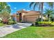 Well-maintained home with a terracotta roof, tidy landscaping, and a double garage on a sunny day at 13347 Golf Pointe Dr, Port Charlotte, FL 33953