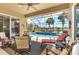 Enclosed lanai with ample seating and a view of the pool, lake and lush landscaping at 13347 Golf Pointe Dr, Port Charlotte, FL 33953