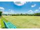 Well manicured lawn bowling area with lush green grass and inviting benches at 13347 Golf Pointe Dr, Port Charlotte, FL 33953