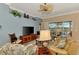 Comfortable living room featuring a ceiling fan, tan leather sofa, and views of the pool and lanai at 13347 Golf Pointe Dr, Port Charlotte, FL 33953