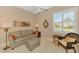 Comfortable living room with a neutral sofa, ottoman, and a decorative window with plantation shutters at 13347 Golf Pointe Dr, Port Charlotte, FL 33953